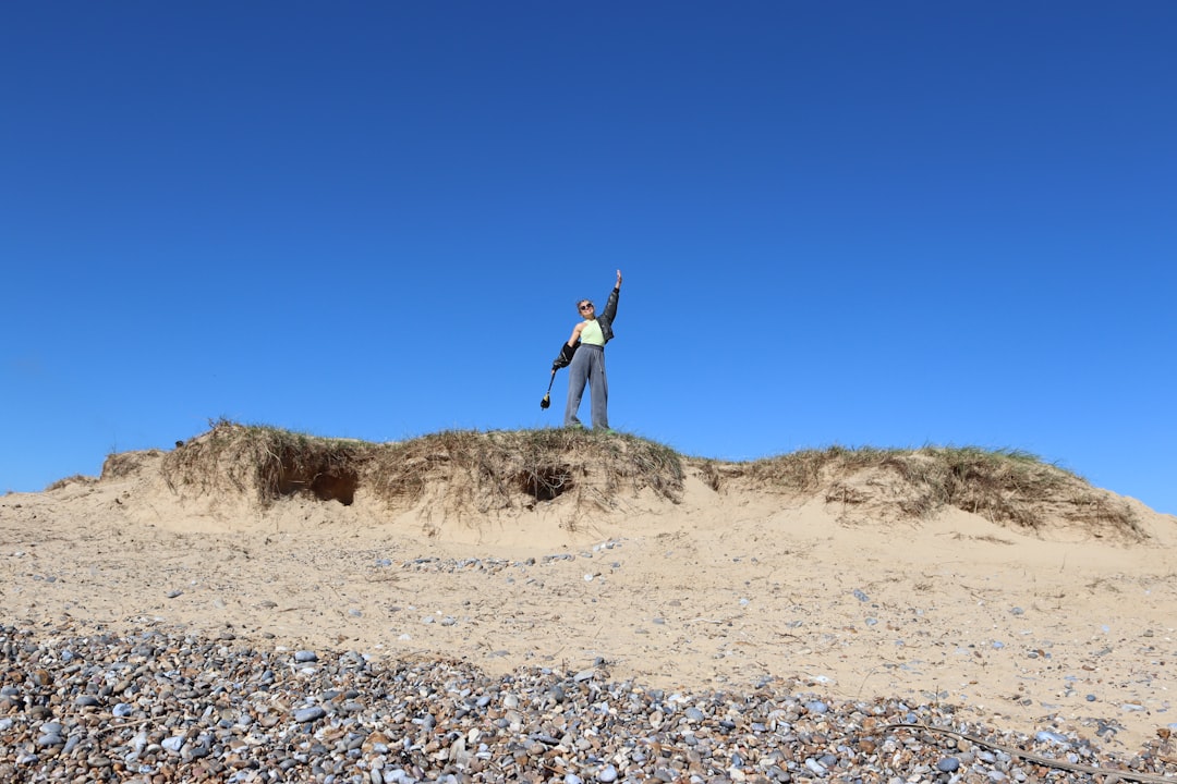 a man standing on top of a sandy hill